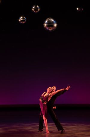Two dancers from Giordano Dance Chicago embrace with bubbles floating above