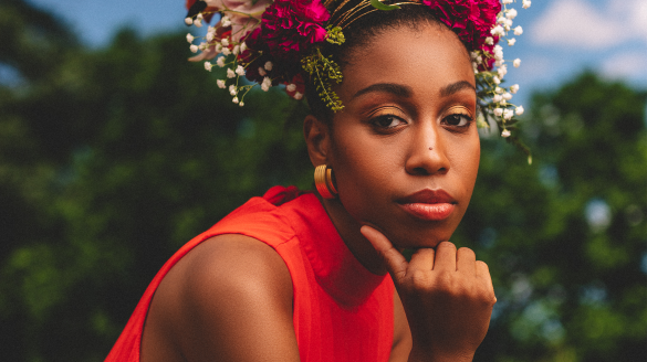Jazzmeia Horn wears a bright orange top with a flower crown on her head
