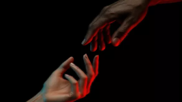 Two hands reaching for each other.