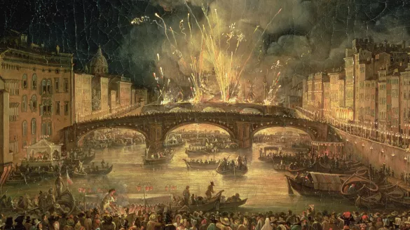 Image of fireworks over a bridge with boats on the river and a crowd