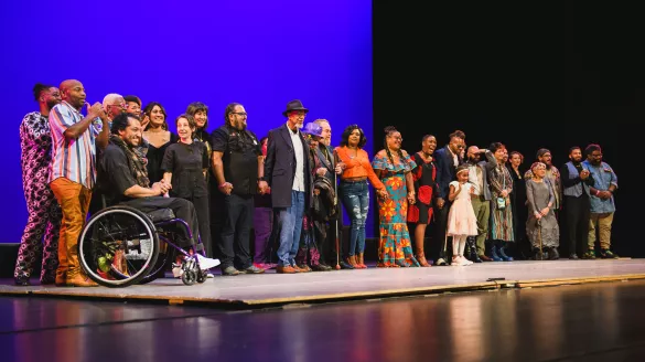 A large group of people on stage looking out to the audience.