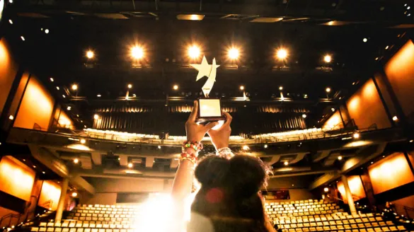 Award being proudly hoisted towards the bright lights of the Harris Theater.
