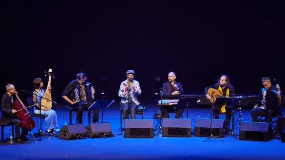 An ensemble of musicians on stage performing.