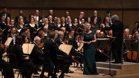 An opera singer performing with an orchestra.