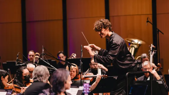 Steve Hackman conducting an orchestra.