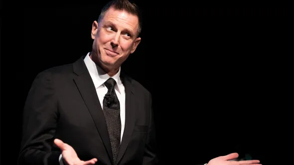 A man in a suit shrugging.