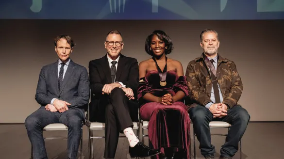 Four people sitting in a row.