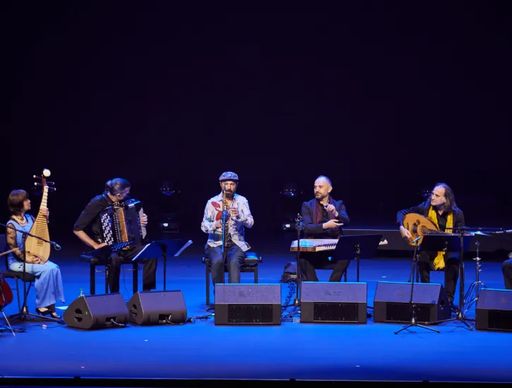 An ensemble of musicians on stage performing.