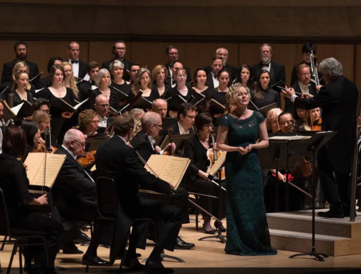 An opera singer performing with an orchestra.