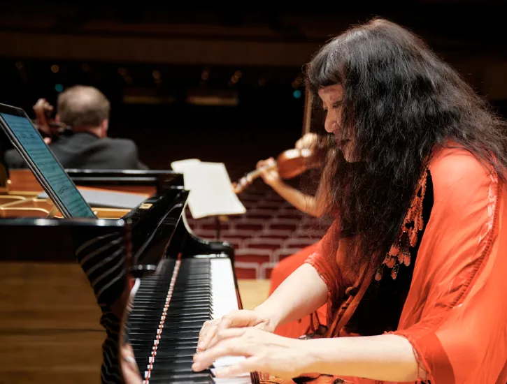 Wu Han playing the piano while other musicians play in the background